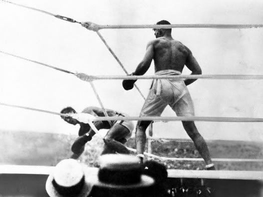 Carpentier is driven through the ropes by the fury of Dempsey's attack.